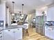 Open kitchen with white cabinets, granite countertops, and stainless steel appliances next to the living space at 5105 Tynewick Ne Trce, Roswell, GA 30075