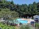 Inviting community pool with lounge chairs and umbrellas surrounded by lush greenery and a secure fence at 5105 Tynewick Ne Trce, Roswell, GA 30075