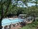 Community pool area features lounge seating, umbrellas, and a gazebo with mature trees around at 5105 Tynewick Ne Trce, Roswell, GA 30075