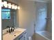 Bathroom features modern vanity with black fixtures, and a tub shower with marble surround at 76 Burbank Dr, Atlanta, GA 30314