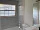 Bright bathroom featuring gray marbled tile in shower with window and view of the outdoors at 76 Burbank Dr, Atlanta, GA 30314