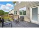 Relax on the back deck with chairs, a table and a view of the spacious backyard with trees at 7698 Hansel Ln, Lithonia, GA 30058