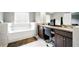 Well-lit bathroom with double sinks, a makeup station, tub, and vanity with great lighting at 7698 Hansel Ln, Lithonia, GA 30058