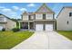 Two-story home featuring a well-manicured lawn and a two-car garage at 7698 Hansel Ln, Lithonia, GA 30058