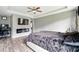 Relaxing main bedroom featuring wood floors, a ceiling fan, electric fireplace, and a workspace at 7698 Hansel Ln, Lithonia, GA 30058