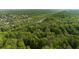 Aerial view of a wooded area with a river running through it and homes in the distance at 900 Edgewater Nw Dr, Atlanta, GA 30328