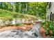 Landscaped backyard featuring a stone walkway with lush greenery and trees at 900 Edgewater Nw Dr, Atlanta, GA 30328