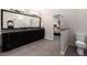 Bathroom featuring double sink vanity, black cabinets, granite counters, and neutral tile floor at 900 Edgewater Nw Dr, Atlanta, GA 30328