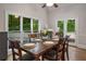 Light-filled dining room with a wood table set for six and scenic backyard views through large windows at 900 Edgewater Nw Dr, Atlanta, GA 30328