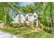 Beautiful two-story home with white exterior, black trim, landscaped yard and mature trees at 900 Edgewater Nw Dr, Atlanta, GA 30328