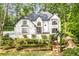 Stunning two-story white home with lush landscaping and a charming entrance, surrounded by mature trees at 900 Edgewater Nw Dr, Atlanta, GA 30328