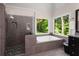 This primary bathroom boasts a standalone tub, walk-in shower, and double vanity with granite countertops at 900 Edgewater Nw Dr, Atlanta, GA 30328