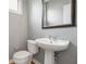 Cozy powder room featuring a pedestal sink, chrome fixtures, and a decorative framed mirror at 1360 Peter Haughton Nw Way, Atlanta, GA 30318