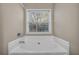 Relaxing bathroom featuring a soaking tub with a window view, a perfect retreat for relaxation at 1538 Park Grove Dr, Lawrenceville, GA 30046