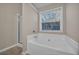 Bright bathroom featuring a soaking tub, glass shower, and a window view of the outdoors at 1538 Park Grove Dr, Lawrenceville, GA 30046