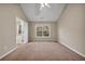 Neutral-toned bedroom with a ceiling fan and natural light, showcasing cozy carpeting at 1538 Park Grove Dr, Lawrenceville, GA 30046