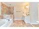 Bathroom with stone tile, a soaking tub, and a glass-enclosed shower at 20 Daniel Crk, Sugar Hill, GA 30518