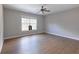 Spacious bedroom features wood flooring, a ceiling fan, neutral walls, and a window for natural light at 20 Daniel Crk, Sugar Hill, GA 30518