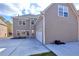 Rear exterior view featuring a gray siding, a two-car garage, and a concrete driveway at 20 Daniel Crk, Sugar Hill, GA 30518