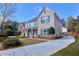 Beautiful home featuring brick accents, manicured landscaping and a long concrete driveway on a sunny day at 20 Daniel Crk, Sugar Hill, GA 30518