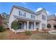 Elegant two-story home with a brick and siding exterior, enhanced by a cozy front porch and lush landscaping at 20 Daniel Crk, Sugar Hill, GA 30518