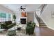 Staged living room with a fireplace, large windows, and a staircase to the second floor at 20 Daniel Crk, Sugar Hill, GA 30518
