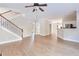 Open-concept living room with wood floors, a ceiling fan, and a staircase at 20 Daniel Crk, Sugar Hill, GA 30518