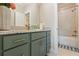 Beautiful bathroom boasts granite counters, green cabinetry, and a tiled shower-tub combo at 2989 Waterford Dr, Conyers, GA 30094