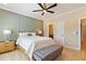 Well-lit bedroom features a ceiling fan, paneled wall, and light wood furniture at 2989 Waterford Dr, Conyers, GA 30094