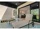 Covered patio with chairs leads into house with visible modern kitchen and beautiful outdoor view at 2989 Waterford Dr, Conyers, GA 30094