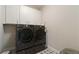 Laundry room boasts new appliances, decorative tile, and bright cabinets at 2989 Waterford Dr, Conyers, GA 30094