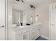 A modern bathroom featuring double sinks, a large mirror, and white cabinetry at 3604 Silvery Way, Powder Springs, GA 30127