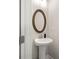 A well-lit pedestal sink bathroom with an oval mirror, neutral tones, and modern fixtures at 3604 Silvery Way, Powder Springs, GA 30127