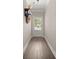 Hallway with light-colored wood floors, a glass-paneled door, and a decorative wall shelf at 3604 Silvery Way, Powder Springs, GA 30127