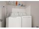 Laundry room with white washer and dryer, storage shelf, and ironing board, maximizing utility at 3604 Silvery Way, Powder Springs, GA 30127