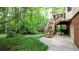 The backyard with lush greenery features a staircase leading up to the house at 1855 Vintage Dr, Snellville, GA 30078