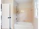 Clean bathroom showcases a bathtub and shower with neutral tiling, accented by a bright window at 1855 Vintage Dr, Snellville, GA 30078