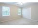 Bright bedroom features neutral carpet, walls, ceiling fan, and closet, enhanced by two windows for natural light at 1855 Vintage Dr, Snellville, GA 30078