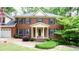 Charming brick two-story home featuring a manicured front lawn and a welcoming front porch at 1855 Vintage Dr, Snellville, GA 30078