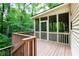 Screened porch with wood flooring and ceiling fan, offering a relaxing view of the surrounding trees at 1855 Vintage Dr, Snellville, GA 30078