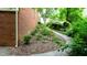 An exterior side yard view with a walkway, retaining wall, and lush, mature landscaping at 1855 Vintage Dr, Snellville, GA 30078