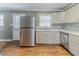 Kitchen with stainless steel refrigerator and white cabinets, sink, and backsplash and wood-look floors at 2586 Williamsburg Dr, Decatur, GA 30034