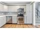 Kitchen with stainless steel appliances and white cabinets, and access to staircase to upper level at 2586 Williamsburg Dr, Decatur, GA 30034