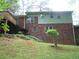 Back of brick and siding house with a deck, grassy hillside, and stairs at 2795 Dodson Lee Dr, East Point, GA 30344