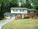Charming two-story home with a brick facade, light green siding, attached garage, and a well-manicured front yard at 2795 Dodson Lee Dr, East Point, GA 30344