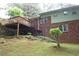 Back of brick and siding house with a deck, grassy hillside, and stairs at 2795 Dodson Lee Dr, East Point, GA 30344
