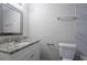 Bathroom with granite countertops, framed mirror, and a toilet with brushed nickel hardware at 3938 Emerald Springs Ct, Decatur, GA 30035