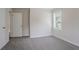 Empty bedroom with neutral walls, carpeted floors, a window and a door at 3938 Emerald Springs Ct, Decatur, GA 30035
