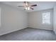 Bedroom with neutral walls, carpeted floors, two windows, fan, and a closet at 3938 Emerald Springs Ct, Decatur, GA 30035