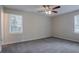 Empty bedroom with neutral walls, carpeted floors, two windows, and a ceiling fan at 3938 Emerald Springs Ct, Decatur, GA 30035